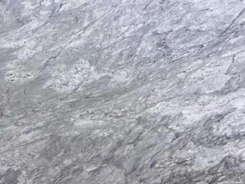 Zbliżenie granitu River White szczotka, jasnoszara powierzchnia z miękkimi, chmurkowymi żyłkami