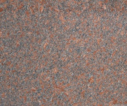Zbliżenie granitu Santiago Red poler, drobnoziarnista czerwono-szara struktura z ciemnymi wtrąceniami