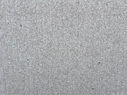 Zbliżenie struktury granitu Semi Moreno Deza płomień, drobnoziarnista szara powierzchnia o szorstkiej fakturze