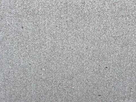 Zbliżenie struktury granitu Semi Moreno Deza płomień, drobnoziarnista szara powierzchnia o szorstkiej fakturze