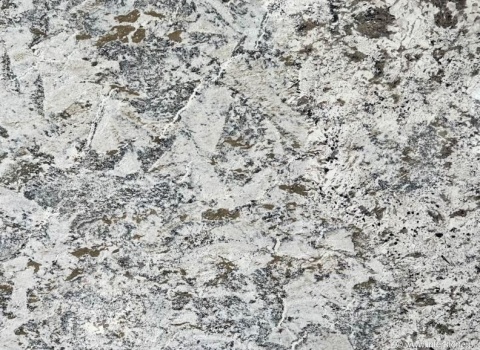 Zbliżenie granitu Siberian White poler, jasne tło z nieregularnymi szaro-brązowymi plamami i kontrastową strukturą