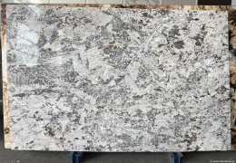 Płyta granitu Siberian White poler, biało-szara tafla z wyrazistym, nieregularnym wzorem, widok całej płyty w hali