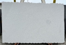 Płyta granitowa Silver Bianco, wykończenie młotek, widok całej płyty na stojaku na zewnątrz