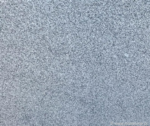 Zbliżenie struktury granitu Silver Bianco poler – jasnoszare, drobnoziarniste tło kamienia dekoracyjnego.