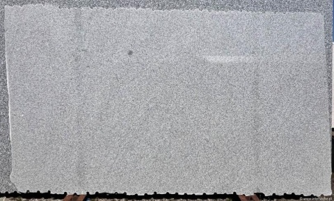 Płyta granitu Silver Bianco poler ustawiona pionowo – jasnoszare, równomierne użylenie idealne na blaty i okładziny.