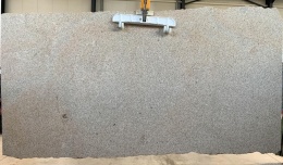 Płyta granitu Silvestre Gold młotek w hali – beżowo-szara tafla kamienia o równomiernej strukturze.