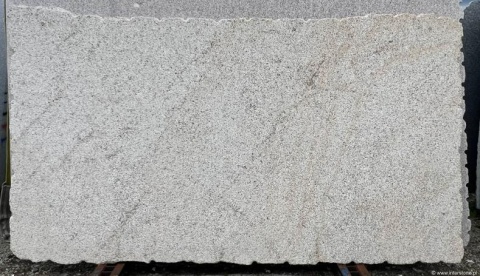 Płyta granitu Silvestre Gold młotek z widocznymi, delikatnymi żyłkami beżu i szarości na jasnym tle.