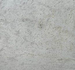 Zbliżenie struktury granitu Spring White – jasne tło z delikatnymi kropkami i smugami.