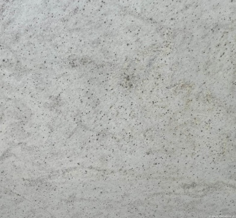 Zbliżenie struktury granitu Spring White – jasne tło z delikatnymi kropkami i smugami.