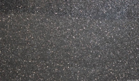 Zbliżenie granitu Star Galaxy – czarne tło z gęstym, złocistym iskrzeniem minerałów.