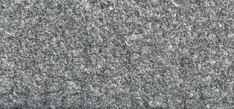 Zbliżenie struktury granitu Steel Grey poler – drobnoziarnisty, szaro-srebrny wzór z jasnymi punktami.
