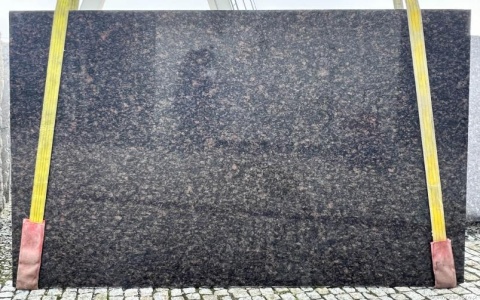 Płyta granitu Tan Brown poler – duży slab z żółtymi pasami transportowymi, ciemnobrązowy odcień z wtrąceniami.