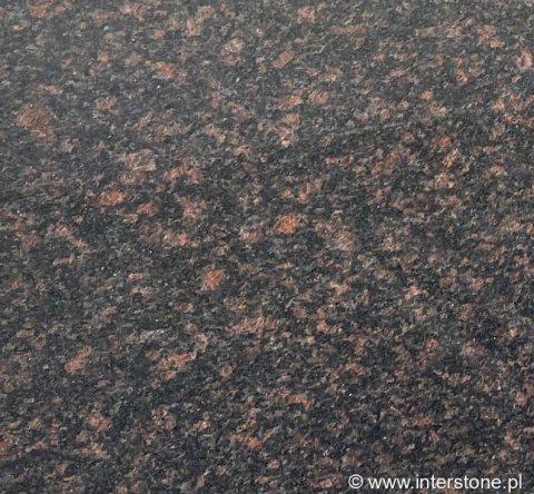 Detal granitu Tan Brown poler – ciemne tło z ciepłymi, brązowymi kryształami; powierzchnia polerowana