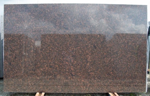 Granit Tan Brown poler – duża płyta o lustrzanym połysku, widoczne odbicia; brązowy wzór kamienia.