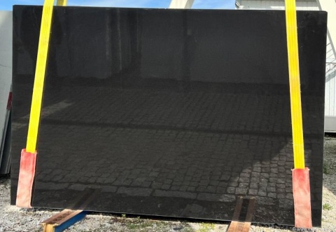 Płyta granitu Ultimate Black – duży, czarny slab o gładkiej powierzchni; widoczne żółte pasy transportowe.