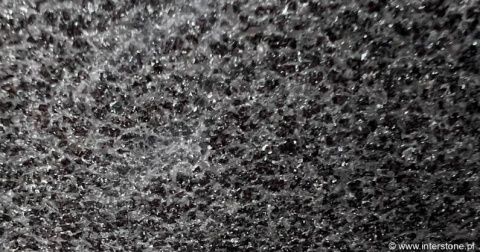 Zbliżenie granitu Ultimate Black – drobnoziarnista, czarna struktura z delikatnym połyskiem kryształów.