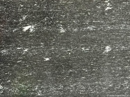 Zbliżenie granitu Via Lattea szczotka – ciemne tło z drobnymi białymi wtrąceniami i delikatnym rysunkiem.