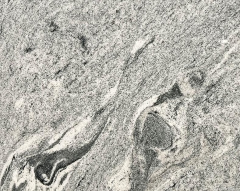 Zbliżenie granitu Viscount White poler – jasnoszare tło z ciemniejszymi falami i drobnym uziarnieniem.