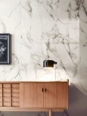 Ściana wykończona spiekiem Marazzi Calacatta Extra z jasnym marmurowym użyleniem w eleganckim wnętrzu.