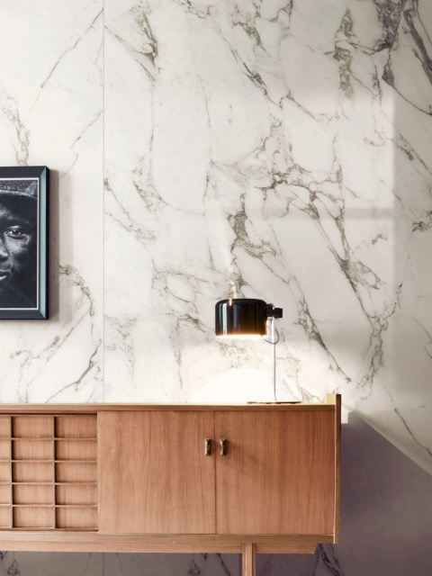 Ściana wykończona spiekiem Marazzi Calacatta Extra z jasnym marmurowym użyleniem w eleganckim wnętrzu.