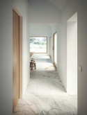Nowoczesny korytarz z podłogą ze spieku Marazzi Calacatta Extra  w białej marmurowej kolorystyce.
