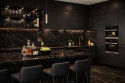 Monochromatyczna kuchnia z Marazzi Elegant Black – czarne blaty i okładzina ścienna z subtelnym marmurowym rysunkiem
