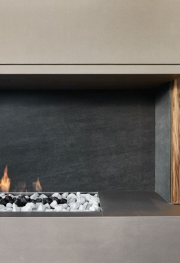 Ciemne płytki Neolith Basalt Black w satynowym wykończeniu zastosowane w nowoczesnej zabudowie kominkowej