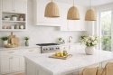 Kuchnia z meblami ecru i spiekiem w chłodnym kremie z subtelnymi szarawymi żyłkami i miękkim rysunkiem