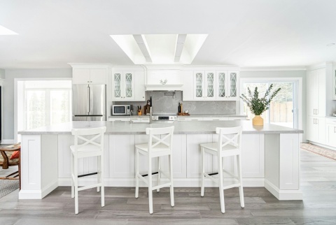 Nowoczesna biała kuchnia z dużą wyspą i blatem Silestone Desert Silver o subtelnym, jasnym użyleniu