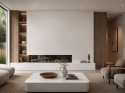 Infinity Absolute White SC01 na ścianie kominkowej i stoliku w nowoczesnym salonie z drewnem.