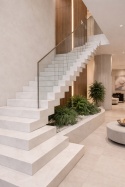 Nowoczesne schody z jasnego konglomeratu kwarco-granitowego w eleganckim wnętrzu z przeszklaną balustradą