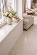 Elegancki salon w stylu neo z parapetem i jasną podłogą z konglomeratu InterQ Fantasy Frost o subtelnym użyleniu