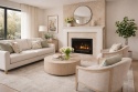 Klasyczny salon z kominkiem wykończonym spiekiem kwarcowym Laminam Fokos Rena w kolorze beżowo-piaskowym, wiosenne dekoracje i jasne meble