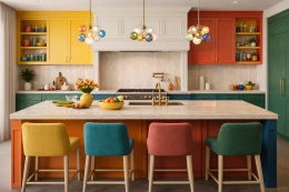 Nowoczesna kuchnia z blatem ze spieku Laminam Hado Travertino Bianco i meblami w żywych kolorach.
