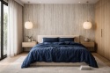 Sypialnia japandi z dekoracyjną ścianą ze spieku Laminam Hado Travertino Silver i pościelą w ciemno-niebieskim kolorze.