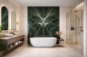 Luksusowa łazienka z ozdobną ścianą Verde Alpi, jasnymi ścianami, wanną wolnostojącą i szklaną kabiną prysznicową.