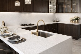 Spiek Laminam Ardesia Bianco a Spacco w kuchni glamour – jasny blat wyspy i okładzina ścienna między meblami.