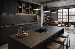 Kuchnia loftowa ze spiekiem Laminam Ardesia Nero a Spacco na blacie i ścianie, otwarta przestrzeń z salonem.