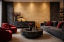 Elegancki salon z dekoracyjną ścianą ze spieku Seta Or, czarnymi meblami oraz czerwonymi fotelami i dodatkami