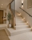 Schody z beżowym spiekiem Techlam Salina Ivory, czarną balustradą, drewnem i ciepłym oświetleniem LED.