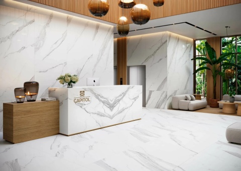 Eleganckie lobby z recepcją wykończoną spiekiem Estatuario Bookmatch – marmurowe ściany i podłogi.