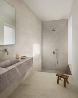 Jasne płytki Marazzi Cementum Ash w minimalistycznej łazience z prysznicem i kamienną umywalką