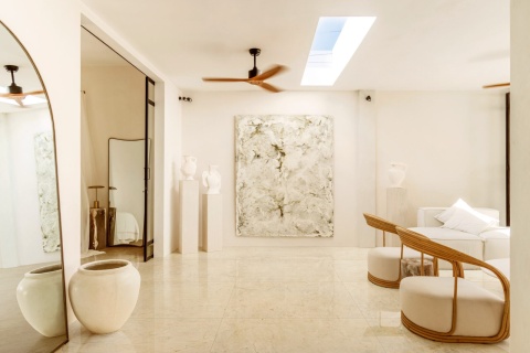 Marazzi Crema Marfil Lux na posadzce jasnego salonu z białymi meblami, drewnianymi fotelami i dużym lustrem