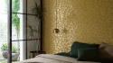 Dekoracyjna ściana Marazzi Luxor za łóżkiem w eleganckiej sypialni z zielonymi tekstyliami i złotą lampą