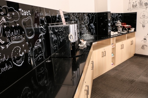 Czarny blat i okładzina ścienna z konglomeratu TechniStone Brilliant Black w kawiarni