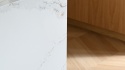 Detal krawędzi wyspy wykończonej konglomeratem TechniStone Calacatta Volegno