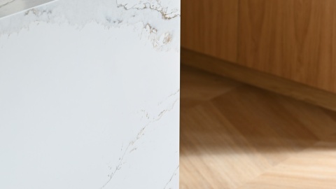 Detal krawędzi wyspy wykończonej konglomeratem TechniStone Calacatta Volegno