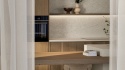 Kuchnia z blatem i ścianą z jasnego konglomeratu TechniStone Emperador Beige