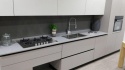 Kuchnia z blatem TechniStone Noble Pro Cloud Poler i jasną nowoczesną zabudową.