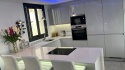 Biała kuchnia z wyspą i polerowanym blatem TechniStone Starlight White